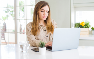 The image shows a person sitting at a desk. They are focused on typing on a laptop computer and engaged in taking a talent assessment, demonstrating the individual's employer has a robust talent management strategy.